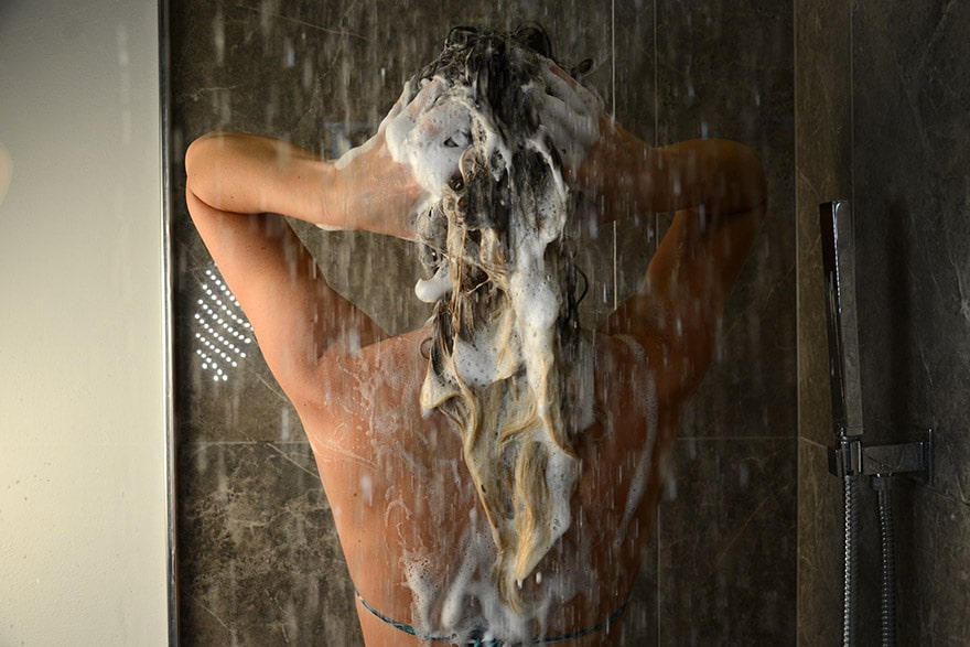 donna che lava i capelli con lo shampoo bio al latte d'asina